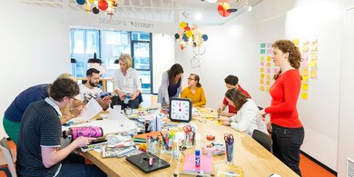 Personengruppe sitzt arbeitend an einem Tisch im Innovation Center 