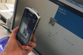 Foto: Handy scannt QR Code auf einem Monitor