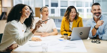 Eine Gruppe von Personen sitzt zusammen am Tisch und lernt